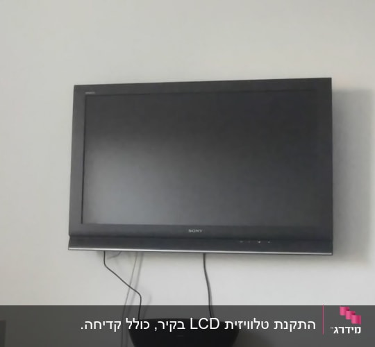 טלוויזיה תלויה על קיר עם כבלים מחוברים
